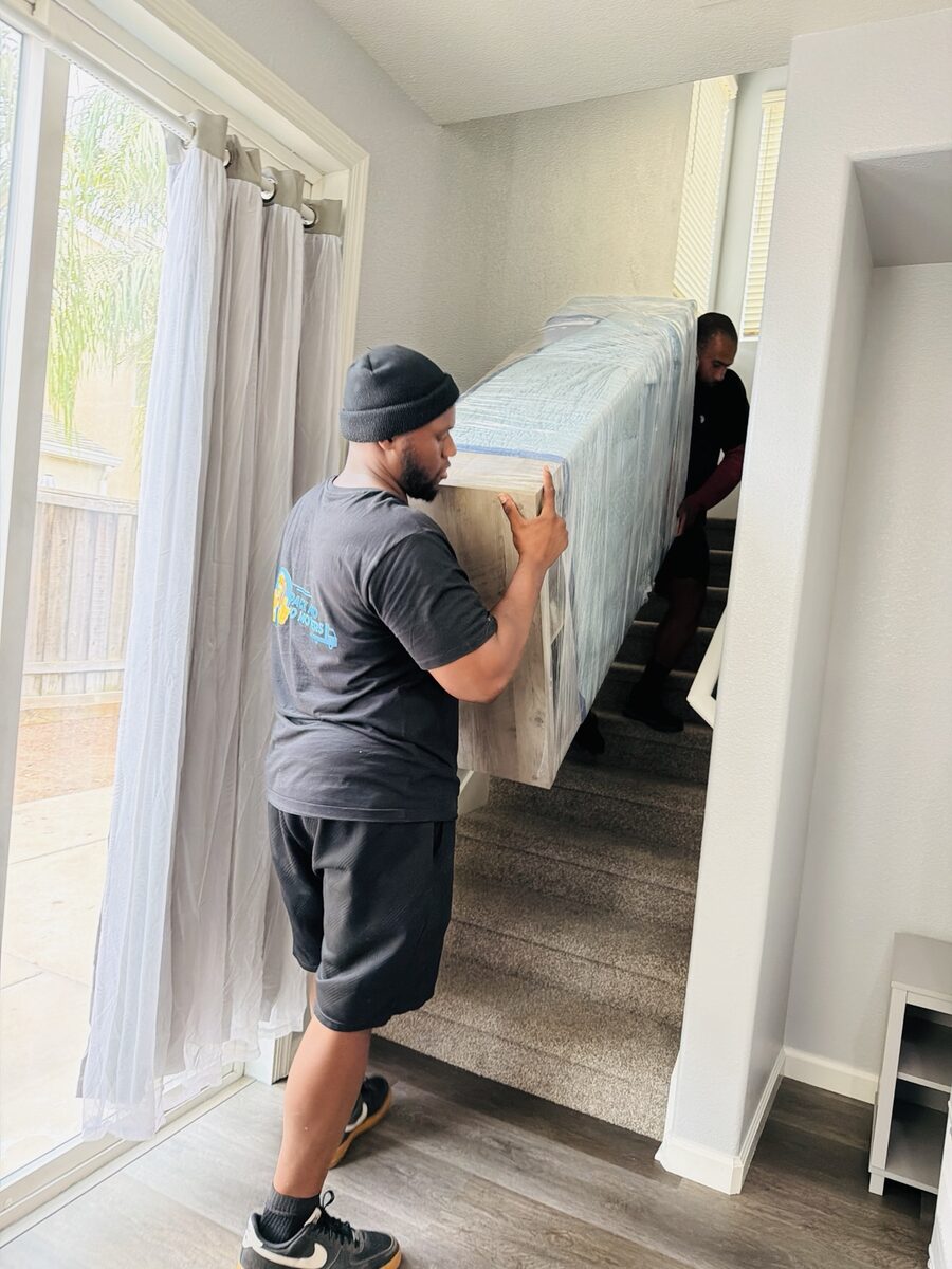 Pack And Go moving team carefully carrying wrapped furniture upstairs